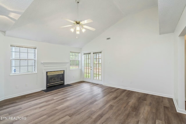unfurnished living room with a ceiling fan, a fireplace with flush hearth, wood finished floors, baseboards, and visible vents