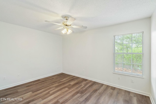 spare room with baseboards, a textured ceiling, wood finished floors, and a ceiling fan