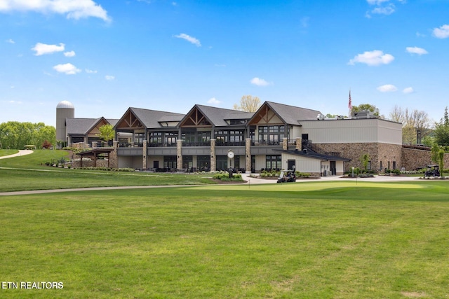 exterior space with golf course view and a lawn
