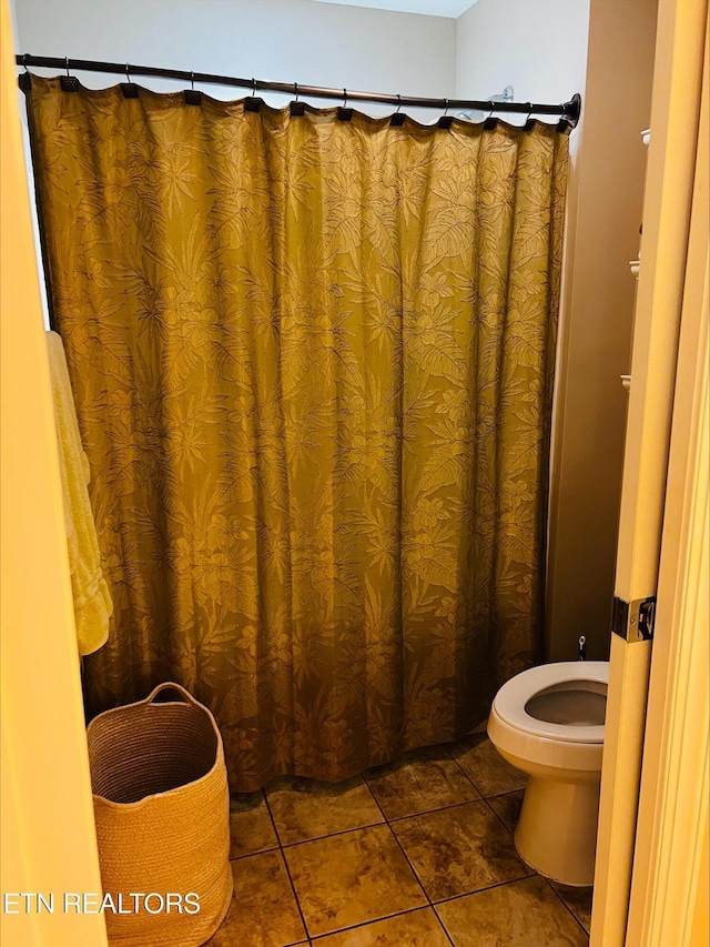 bathroom with toilet and tile patterned flooring