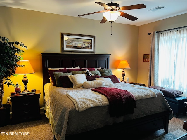 carpeted bedroom with visible vents and a ceiling fan