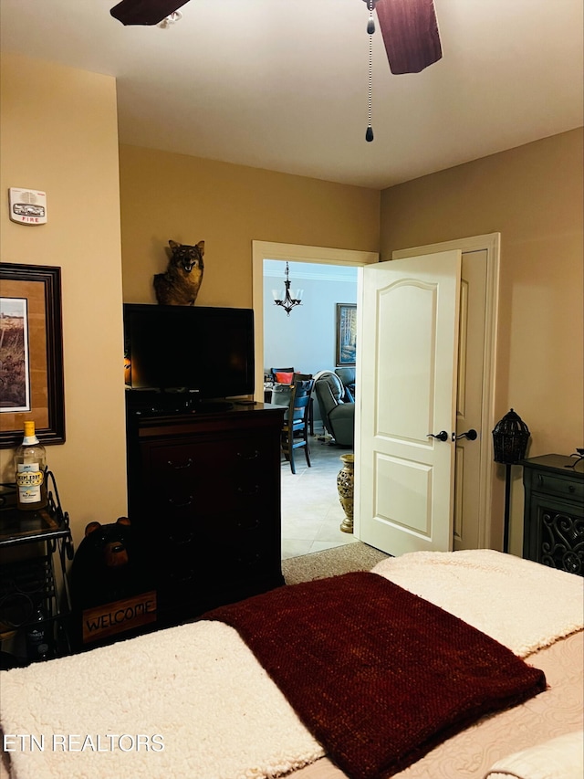 bedroom featuring ceiling fan with notable chandelier