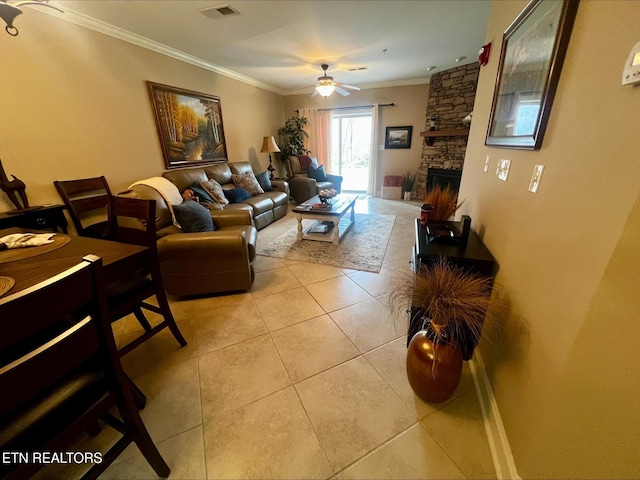 living area featuring visible vents, a fireplace, ornamental molding, a ceiling fan, and light tile patterned floors