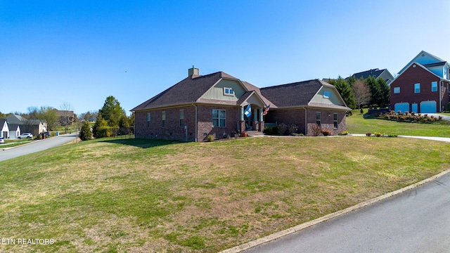 view of front of home with brick siding, a chimney, a front lawn, and a residential view