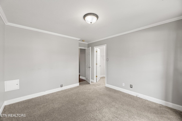 carpeted empty room featuring ornamental molding and baseboards