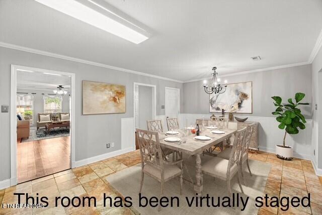dining space with baseboards, a notable chandelier, ornamental molding, and visible vents