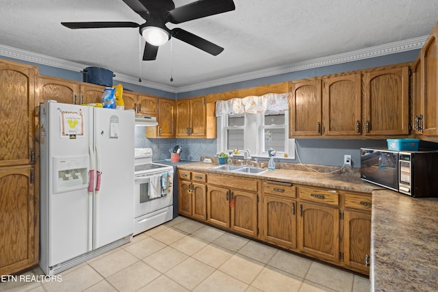 kitchen featuring white appliances, ornamental molding, under cabinet range hood, a sink, and brown cabinetry