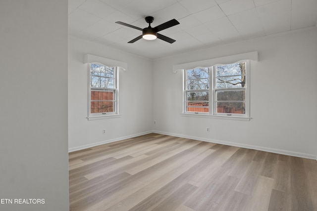 spare room with wood finished floors, baseboards, and ceiling fan