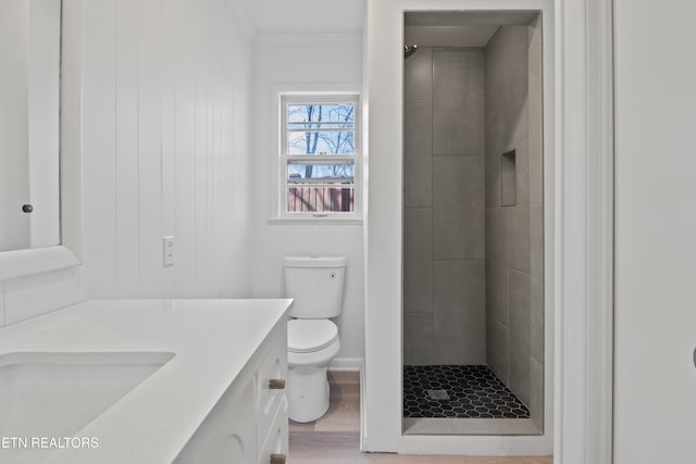 full bath with toilet, wood finished floors, a shower stall, crown molding, and vanity