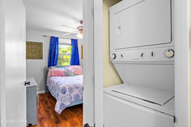 laundry area featuring wood finished floors, stacked washing maching and dryer, laundry area, and ceiling fan
