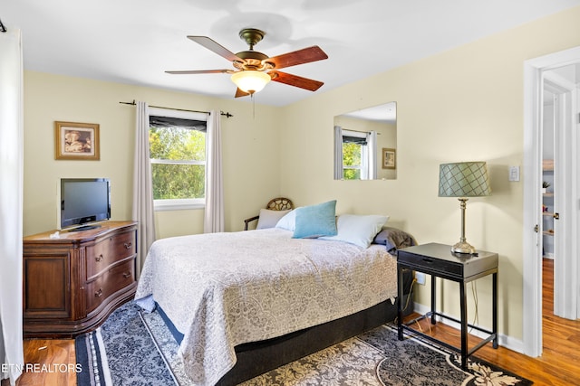 bedroom with baseboards, wood finished floors, and ceiling fan