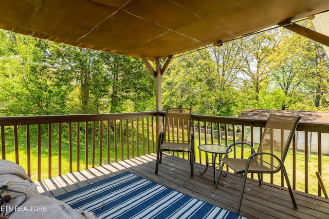 wooden terrace featuring a lawn