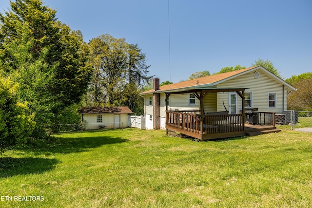 back of house with a yard, a chimney, a fenced backyard, and a deck