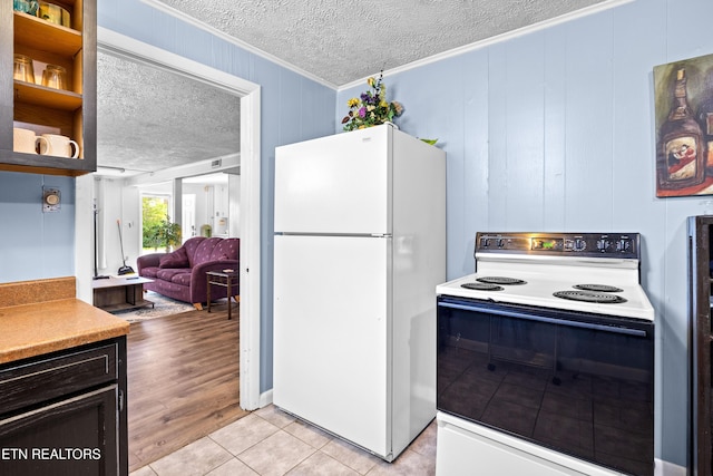 kitchen with range with electric cooktop, a textured ceiling, freestanding refrigerator, ornamental molding, and light tile patterned floors