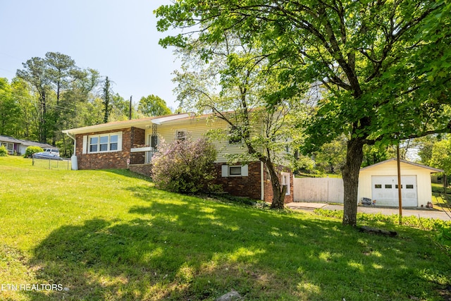 exterior space featuring fence, a front lawn, driveway, an outdoor structure, and brick siding
