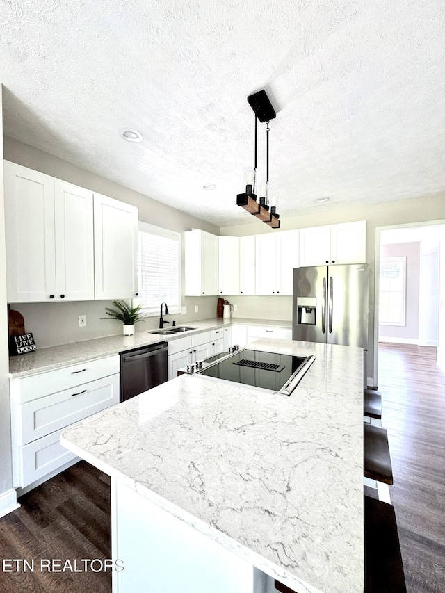 277 Deerfield Way, Lafollette, TN 37766 - kitchen with stainless steel fridge with ice dispenser, dishwasher, a sink, a breakfast bar area, and a textured ceiling