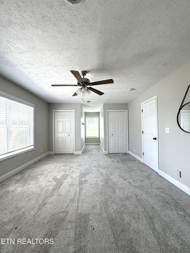 277 Deerfield Way, Lafollette, TN 37766 - unfurnished bedroom with carpet flooring, baseboards, two closets, ceiling fan, and a textured ceiling