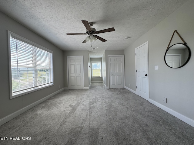 277 Deerfield Way, Lafollette, TN 37766 - unfurnished bedroom with carpet flooring, a textured ceiling, baseboards, multiple closets, and ceiling fan