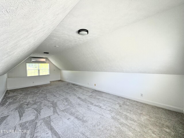 277 Deerfield Way, Lafollette, TN 37766 - additional living space with a wall mounted AC, lofted ceiling, baseboards, carpet floors, and a textured ceiling