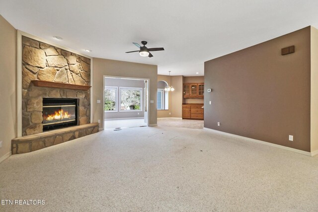 18 Inwood Dr, Fairfield Glade, TN 38558 - unfurnished living room with carpet flooring, a stone fireplace, ceiling fan with notable chandelier, and baseboards