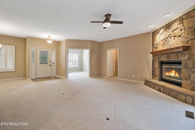18 Inwood Dr, Fairfield Glade, TN 38558 - unfurnished living room with carpet flooring, a stone fireplace, baseboards, visible vents, and ceiling fan