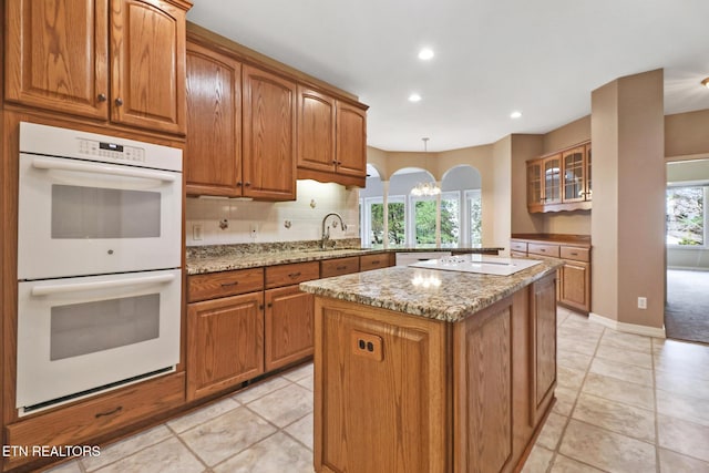 18 Inwood Dr, Fairfield Glade, TN 38558 - kitchen with electric cooktop, tasteful backsplash, white double oven, light stone countertops, and brown cabinets