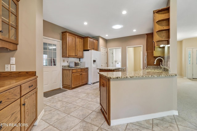 18 Inwood Dr, Fairfield Glade, TN 38558 - kitchen featuring a peninsula, white fridge with ice dispenser, a sink, open shelves, and light stone counters