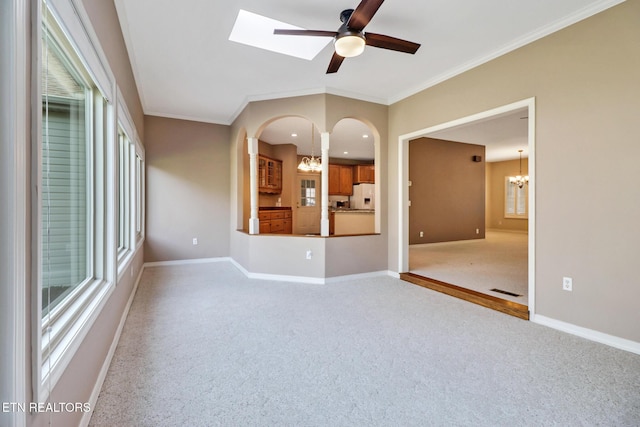 18 Inwood Dr, Fairfield Glade, TN 38558 - empty room with baseboards, ornamental molding, light carpet, arched walkways, and ceiling fan with notable chandelier