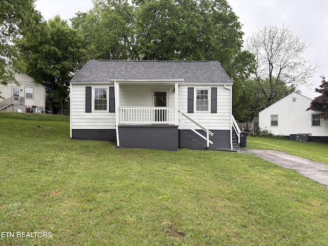 bungalow-style house featuring roof with shingles, central AC, a front yard, and crawl space