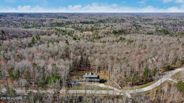drone / aerial view featuring a wooded view