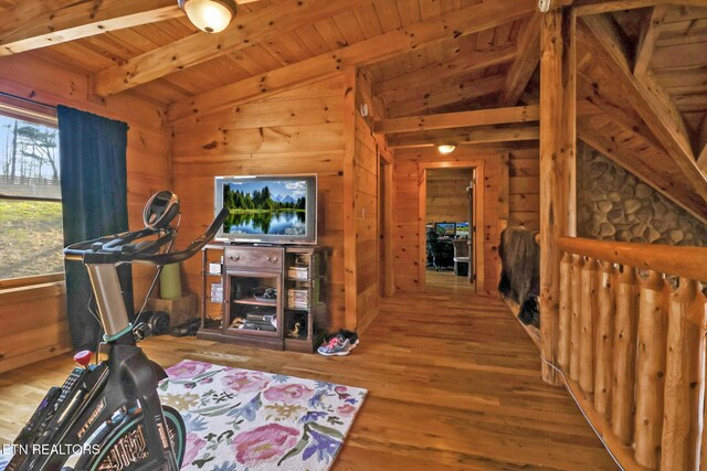 exercise room with wooden ceiling, vaulted ceiling, wood walls, and wood finished floors