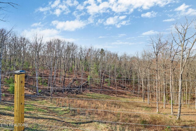 view of yard featuring a view of trees and fence