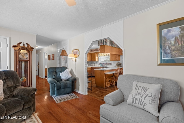 living area with a textured ceiling and wood finished floors