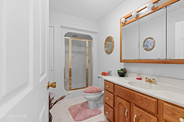 bathroom featuring vanity, toilet, a textured ceiling, tile patterned floors, and a stall shower