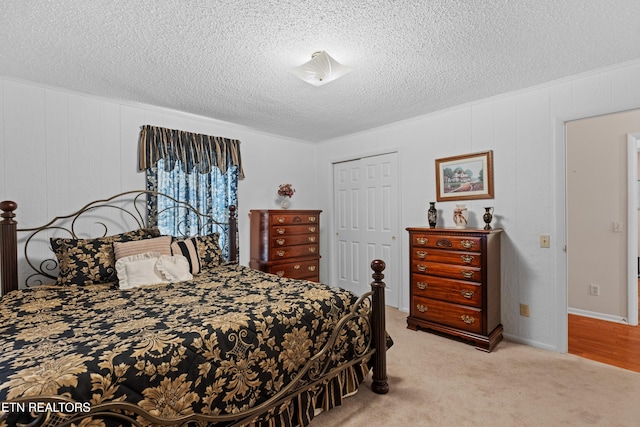 bedroom with a closet, a textured ceiling, and light colored carpet