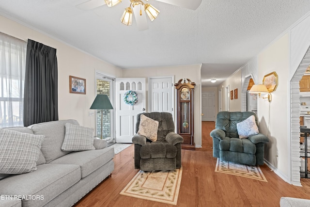 living room featuring a textured ceiling, ceiling fan, and wood finished floors