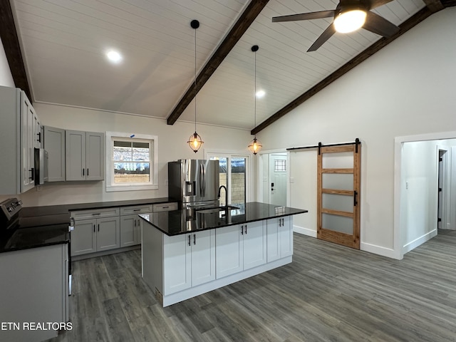 kitchen featuring dark countertops, stainless steel refrigerator with ice dispenser, a barn door, and a ceiling fan