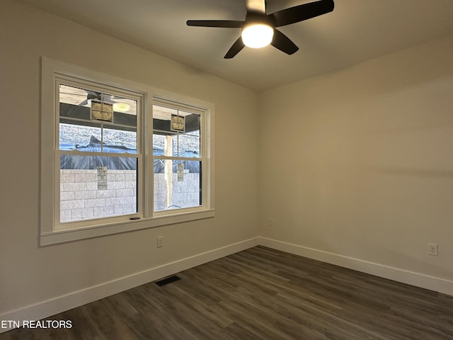spare room with dark wood-type flooring, baseboards, and visible vents