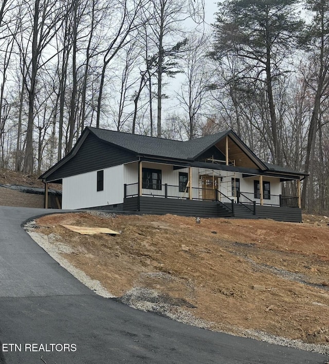 view of front of property with driveway, crawl space, and covered porch