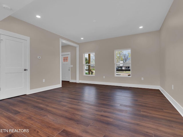 unfurnished living room with recessed lighting, baseboards, and dark wood finished floors