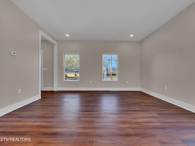 empty room with recessed lighting, baseboards, and wood finished floors