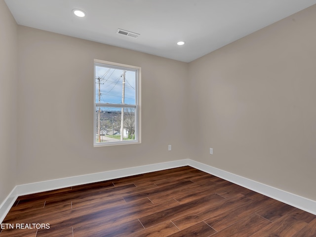 spare room with dark wood-style flooring, recessed lighting, baseboards, and visible vents