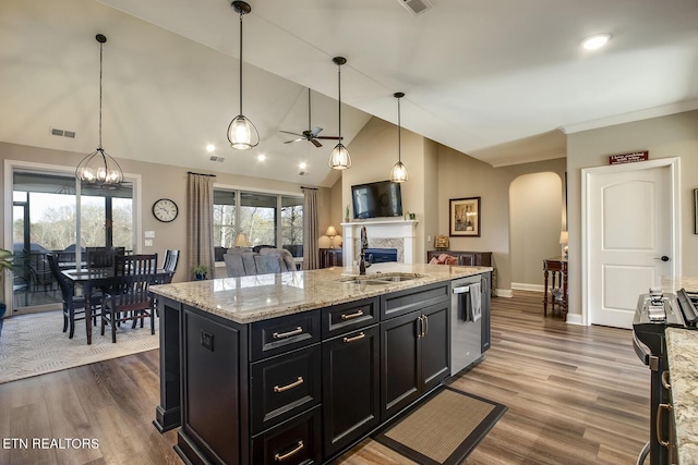 kitchen with a sink, appliances with stainless steel finishes, ceiling fan with notable chandelier, visible vents, and arched walkways