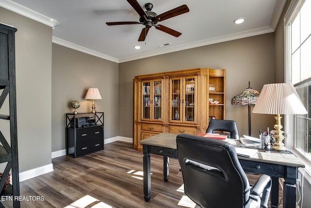 office featuring crown molding, baseboards, dark wood-style floors, visible vents, and a ceiling fan