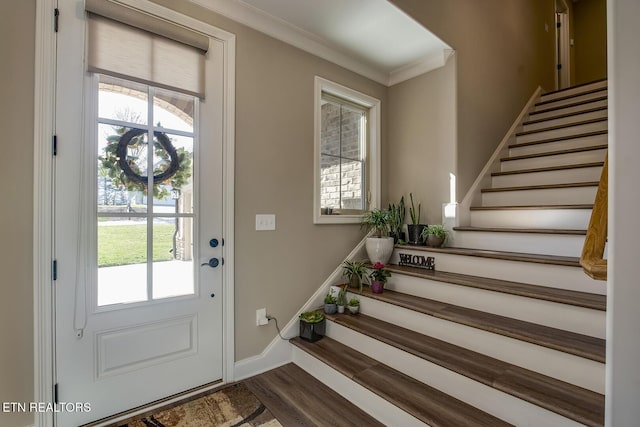 foyer entrance with baseboards, stairs, ornamental molding, and dark wood-style floors