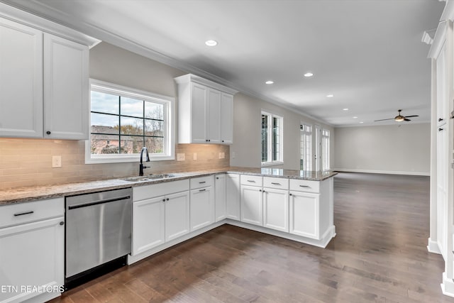 kitchen with dark wood-type flooring, a peninsula, ornamental molding, dishwasher, and a sink