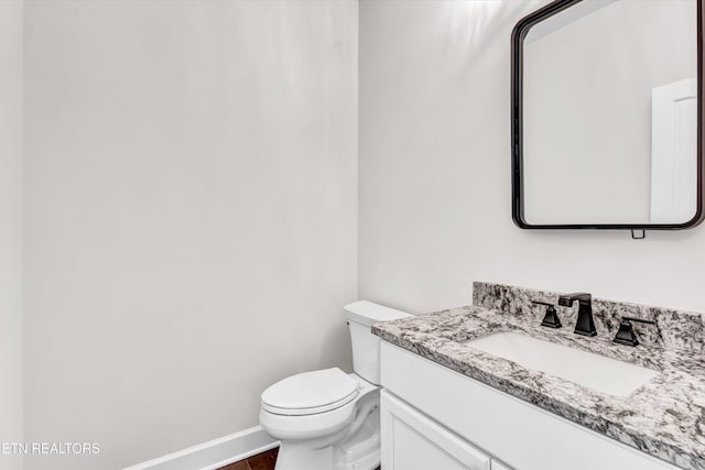 bathroom with vanity, baseboards, toilet, and wood finished floors