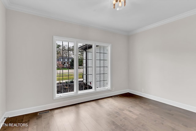 unfurnished room with ornamental molding, visible vents, and baseboards