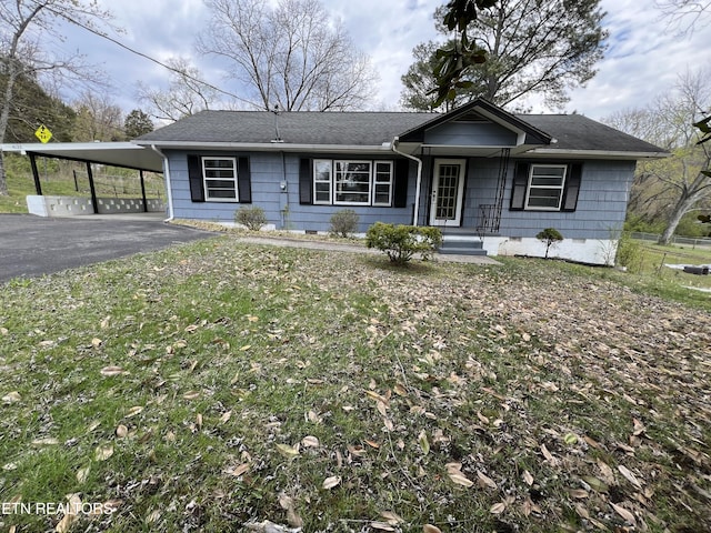 ranch-style home featuring a front yard, crawl space, a carport, and aphalt driveway