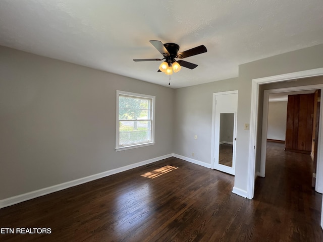 unfurnished bedroom featuring baseboards, ceiling fan, and dark wood finished floors